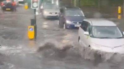 Wave forms as car pushes through flooding