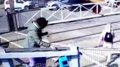 CCTV shows two people ignoring a closed crossing and walking over tracks before a train speeds past.
