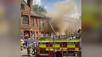 Pictures show crews spraying water on a building after a electrical fire in a basement.