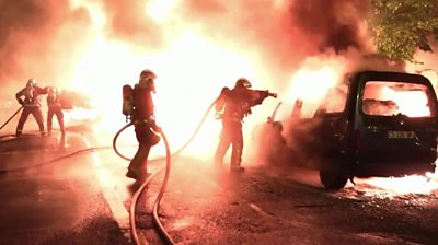 Firefighters hosing down a burning van