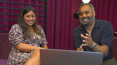 Rhianna Dhillon y Marc Cieslak sentados y mirando una computadora portátil