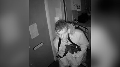 CCTV footage of a burglar inside a house.