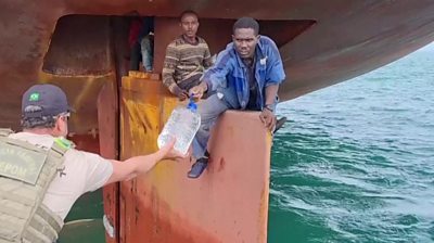 Migrants on ship's rudder given water by Brazilian federal police
