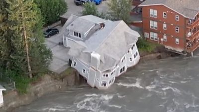 A building falling into a river