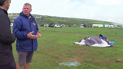 Campsite owner Mike Harris stands near damaged tents