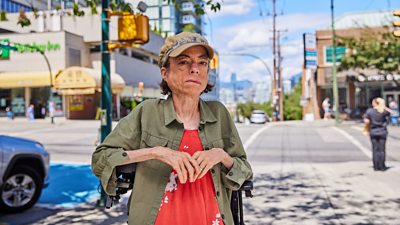 Liz Carr in front of a sunny street view