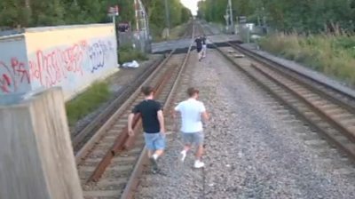 Children running along railway lines