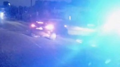 Still from video showing police car hitting another car