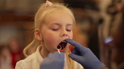 Girl getting teeth checked.