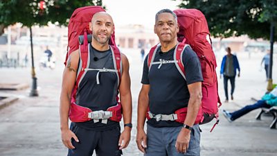 Alex Beresford and dad Noel posing with big red backpacks 