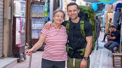 Emma Judd & Harry Judd standing on a street, with backpacks