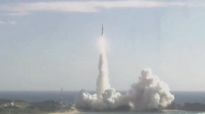 Rocket launching with sea and sky in background