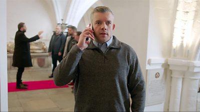 Russell Tovey standing a hall on the phone