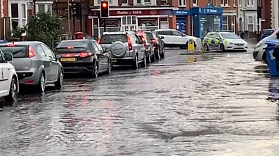 Drains overflowed and manhole covers were lifted along the road near a town centre.