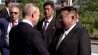 Vladimir Putin and Kim Jong Un shake hands