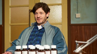 Iwan Rheon sat in a GP room in front of ten pill bottles