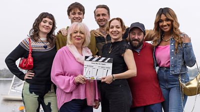 Photo of cast of Here We Go series two pictured holding a clapperboard. 