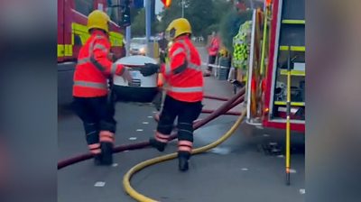 Firefighters lift delivery robot over hoses