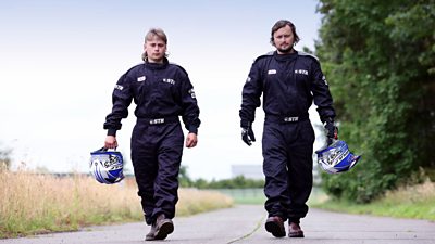 Tom and Ben walking with helmets in their hands