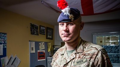 Man in army uniform in office with White on his name tag