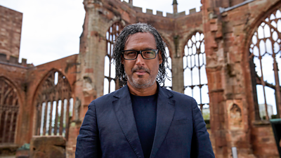 David Olusoga with a ruined church behind him