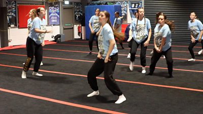 Dancers doing a routine in a gym