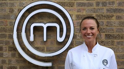 Woman wearing chefs clothing smiling in front of MasterChef M