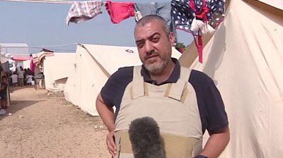 The BBC's Rushdi Abualouf stands inside a camp in Gaza, where thousands of displaced people are living in tents.