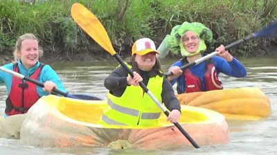 Kayakers in giant pumpkin boats