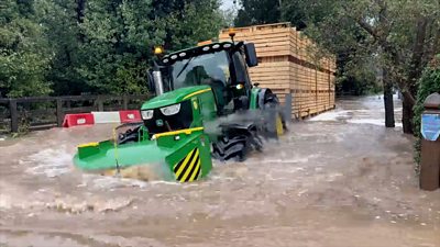 A tractor driving through Rufford Lane ford