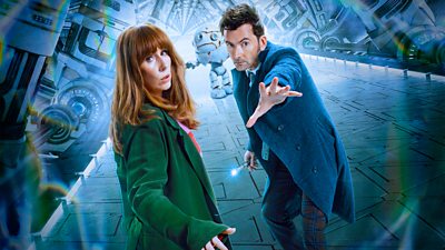 The Fourteenth Doctor and Donna Noble stand on a large mechanical platform. A white robot is visible behind them.