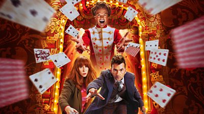 The Toymaker towers over Donna and The Fourteenth Doctor, with playing cards flying through the air from a lit up arch