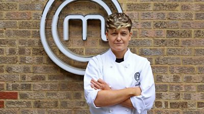 Woman wearing chefs shirt in front of MasterChef M