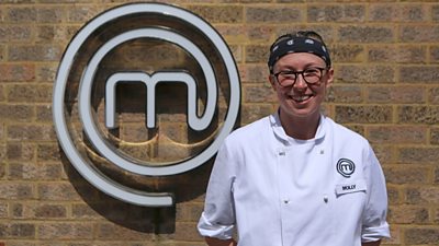 Woman wearing chefs shirt in front of MasterChef M