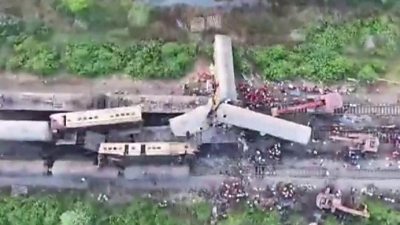 Aerial view of train coaches derailed and sitting on their side on tracks
