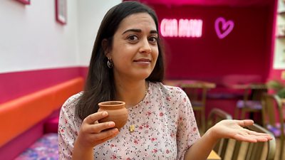 BBC reporter holds cup of chai