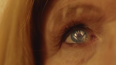 Image from Festival Of Slaps featuring a close-up of the human eye with an outstretched hand reflected in their pupil.