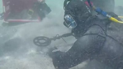 Scuba diver using a metal detector