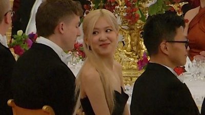 Member of Blackpink smiles at banquet table