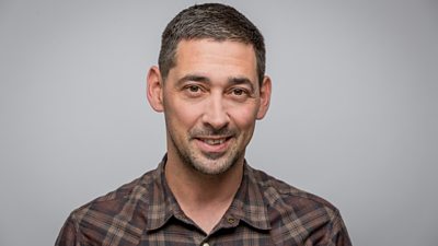 Headshot of Colin Murray smiling to camera.