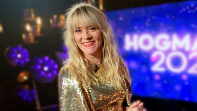Edith Bowman in a gold sequin top smiling to camera. 