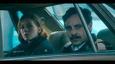 Charlotte Spencer and Emun Elliott in a car looking out pensively 