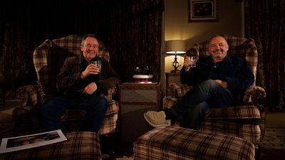 Paul Whitehouse and Bob Mortimer relax in armchairs, raising a glass