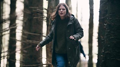 Kirsten Longacre (Rose Leslie) runs through a forest looking concerned.  