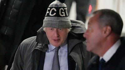 Boris Johnson getting into a car with a hat on