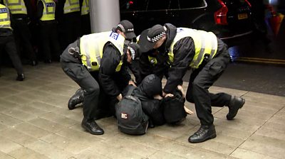 Police grapple with a protester on the ground