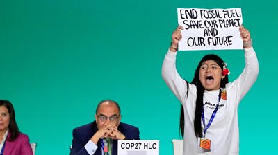Licypriya Kangujam shouting and holding up a sign at COP28