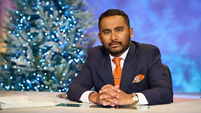 Amol Rajan sat at the University Challenge desk with a Christmas tree in the background. 