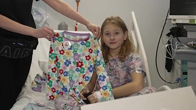Hospital patient Eva with a pair of gifted pyjamas