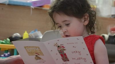 four-year-old Evie Green reading a Christmas card